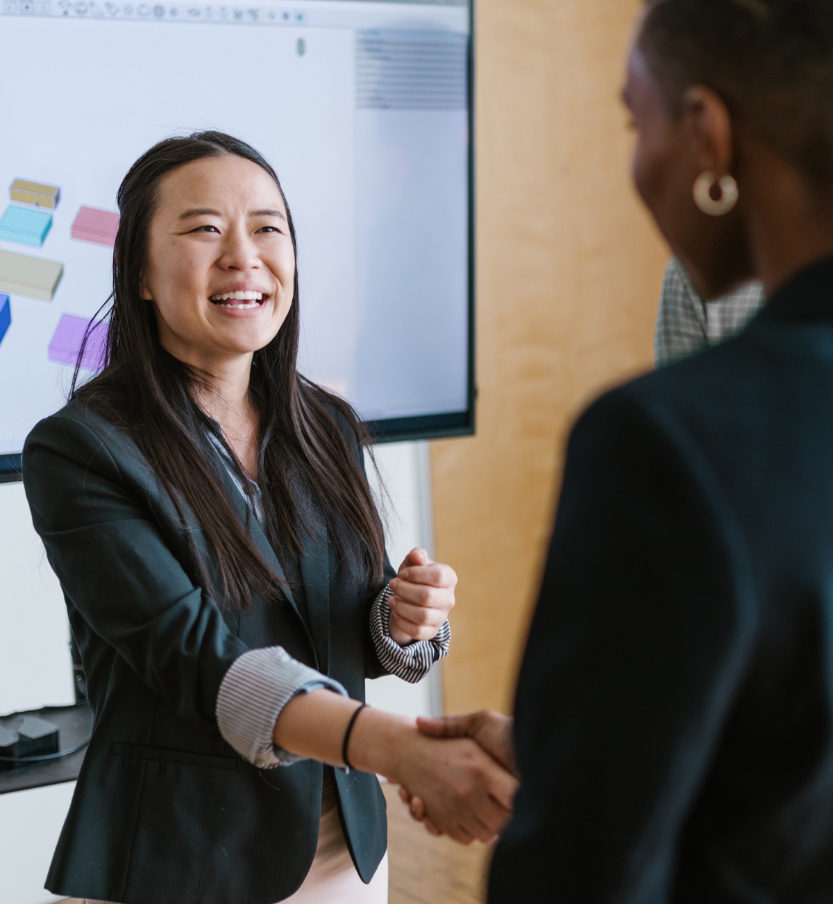 Business professionals shaking hands and smiling